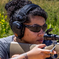 Woman wearing gray-tinted Carhartt Billings safety glasses with a small white Train SMART logo on each side.