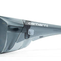 Close-up side view of gray-tinted Carhartt Billings safety glasses with a small white Train SMART logo on each side.