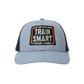 Front view of gray trucker hat with black mesh in the back. Embroided orange, white, and black logo on front of hat reads: TRAIN SMART Everytown Firearms Training.
